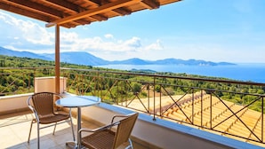 Ein Balkon mit Blick auf eine gebirgige Landschaft und ein Gewässer.