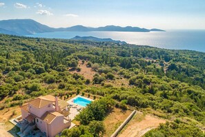 An aerial view of a property with a swimming pool, a two-story building, and a forested landscape with a view of the sea. - Villa Aetos Large Private Pool Sea Views A C Wifi Eco-friendly - 921 (Kefalonia)