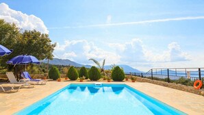 A rectangular pool with clear blue water, surrounded by lounge chairs and umbrellas. - Villa Yeraki Large Private Pool Sea Views A C Wifi - 981 (Kefalonia)