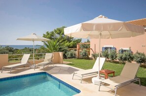 A pool area with lounge chairs and umbrellas, a clear view of the sea, and a well-maintained garden. - Nafsika Beach House Large Private Pool Walk to Beach Sea Views A C Wifi Car Not Required - 1880 (Kefalonia)
