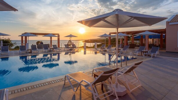 A pool area with lounge chairs and umbrellas, overlooking a body of water during sunset. - Nafsika Beach House Large Private Pool Walk to Beach Sea Views A C Wifi Car Not Required - 1880 (Kefalonia)