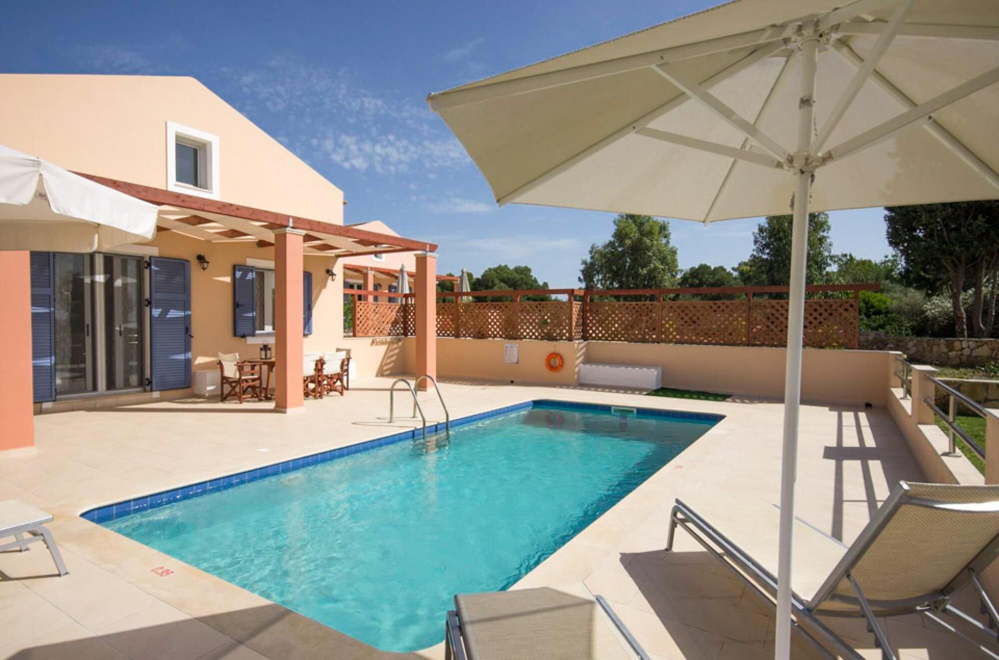 Piscina com pergolado e espreguiçadeiras, área de estar coberta e vista para a paisagem ao redor.