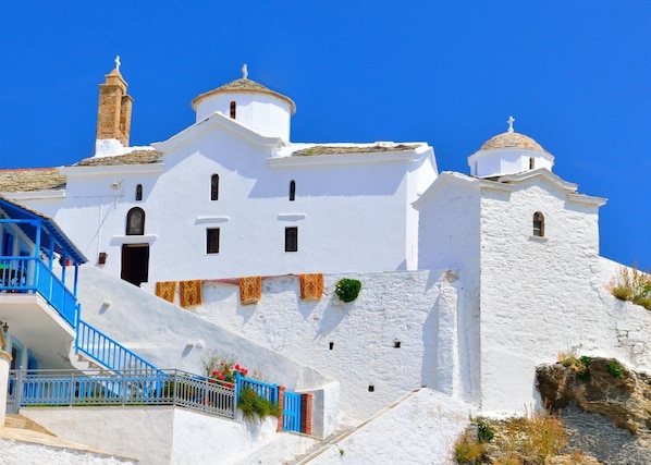 Un edificio blanco con una escalera azul y un balcón pequeño.