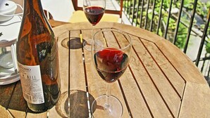 A wooden table with a bottle of wine and two wine glasses on a balcony. - Anna Apartment Walk to Beach A C Wifi Car Not Required - 2451 (Corfu)