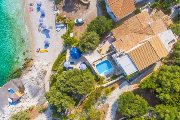 An aerial view of a coastal property with a swimming pool, beach umbrellas, and a beach area. - Villa Thalassa Large Private Pool Walk to Beach Sea Views A C Wifi Car Not Required - 920 (Corfu)