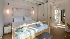 A bedroom with a wooden bed, bedside tables, a bench, and a wardrobe. - Villa Ifigeneia Swimming Pool Walk to Beach Sea Views A C Wifi - 3455 (Paxos)