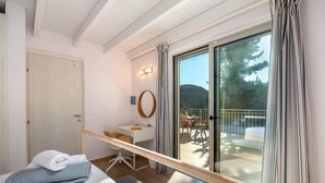 A bedroom with a bed, a desk, a chair, a window, and a balcony with a table and chairs. - Villa Alexandros Swimming Pool Walk to Beach A C Wifi - 3454 (Paxos)