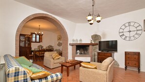 A cozy living room with a fireplace, a television, and a chessboard. - Villa Mealli Large Private Pool Wifi - 3445 (San Casciano dei Bagni)