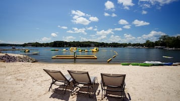 Een privéstrand, wit zand, ligstoelen aan het strand