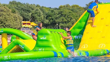 Inflatable water slides and pools with people using them.