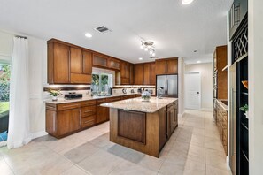 Una cocina moderna con armarios de madera, una isla central y un refrigerador.