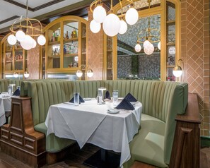 A restaurant interior with green upholstered booths, white tablecloths, and hanging spherical light fixtures. - Hyatt Place Allentown / Lehigh Valley (Allentown)