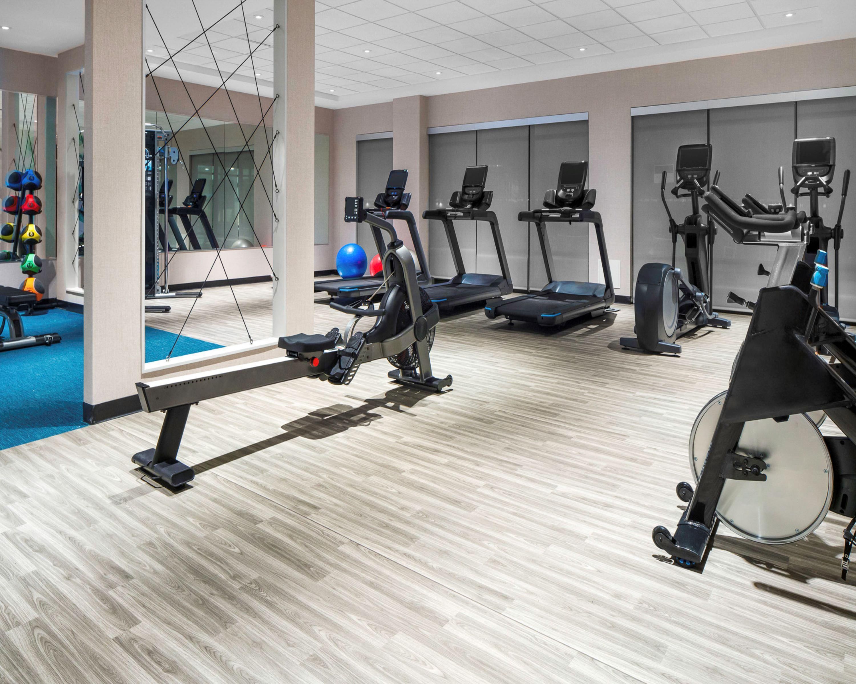 A gym with treadmills, elliptical machines, and a rowing machine.