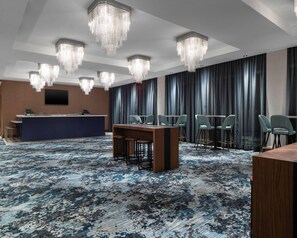 A hotel conference room with a reception desk, multiple tables, chairs, and a large chandelier. - Hyatt Place Allentown / Lehigh Valley (Allentown)