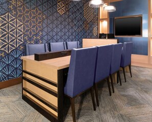 A conference room with a geometric patterned wall, a flat-screen TV, and a carpeted floor. - Hyatt Place Allentown / Lehigh Valley (Allentown)