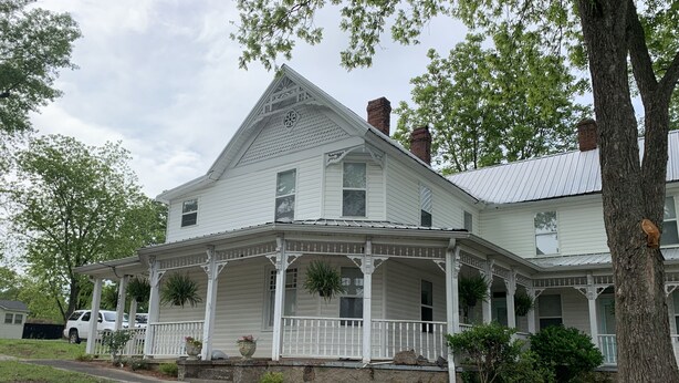 A large white house with a porch, multiple windows, and a chimney. - Private room and bathroom in the heart of Cullman. (Cullman)