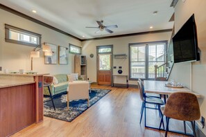 Relax in a spacious living area with a dining table, sofa, and flat-screen TV.