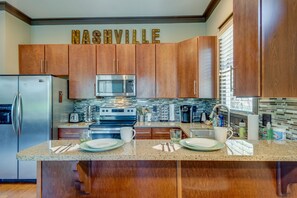 Enjoy cooking in this well-equipped kitchen with a central island, stainless steel appliances, and ample counter space.