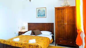 Un dormitorio con una cama de madera, una mesita de noche, un armario y un cuadro en la pared.