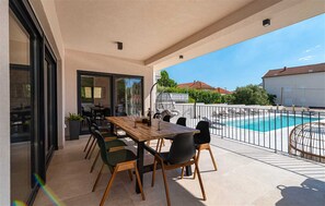A terrace with a pool, dining area, and a view of the neighborhood. - Highly luxurious Villa Magale with large pool (Biograd na moru)