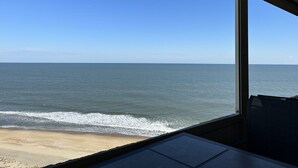 Vista do oceano de uma janela com vista para a praia.