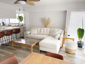 Bright and Cozy Living Room. Bar stools and ottoman poufs for extra seating