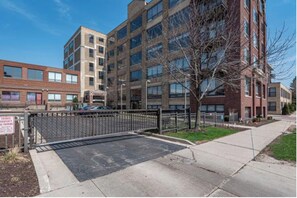 Stunning apartment complex with a brick facade and large windows, offering a secure gated entrance.