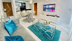 Una sala de estar moderna con sofá, mesa de centro y televisor.