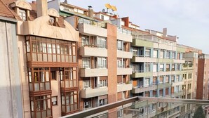 Un immeuble résidentiel à plusieurs étages, doté de balcons, d’un local commercial et d’un passage piétonnier.