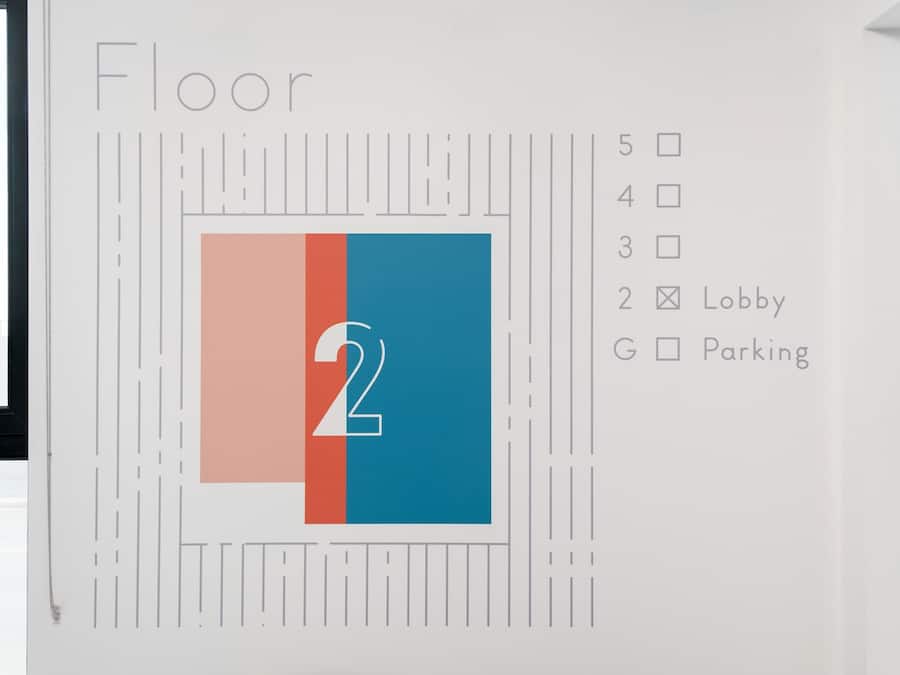 A wall with a floor number '2' and a list of amenities including a lobby and parking.