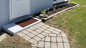 Una casa de fachada blanca, con una puerta principal y un pequeño porche con escalones de acceso.