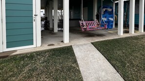 Ein Gebäude mit einer Veranda, einer Schaukel und einer Fischdekoration.