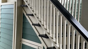 Eine Treppe mit weißen Geländern und einer grünen Tür.