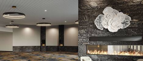 A modern lobby with a patterned carpet, seating area, and a fireplace.