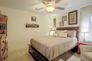 A bedroom with a bed, a nightstand, a dresser, a ceiling fan, and wall-mounted artwork. - Family-Friendly Home w/ Lake Oconee Access + Patio (Eatonton)