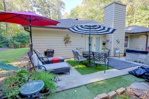 A patio with outdoor furniture, a barbecue grill, and a decorative wall piece. - Family-Friendly Home w/ Lake Oconee Access + Patio (Eatonton)
