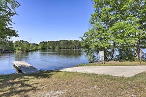 A calm lake with a wooden dock extending into the water, surrounded by lush greenery and trees. - Family-Friendly Home w/ Lake Oconee Access + Patio (Eatonton)