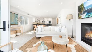 Ein modernes Wohnzimmer mit einem weißen Sofa, einem Couchtisch und einem Kamin.