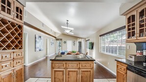 A spacious kitchen with wooden cabinets, a central island, and a large window. - POOL. Spacious 4BR/2B. SF Bay Area (Newark)