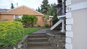 A residential building with a stone staircase leading to a balcony. - Cozy 1 bedroom apartment, near Seattle & Airport. (Normandy Park)