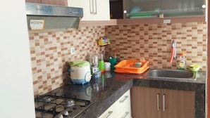 A kitchen with a gas stove, a sink, and cabinets. - Omah Dixy Family Homestay by FH Stay (Baturetno)