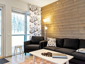 Un salon moderne comprenant un canapé, une table basse et un lampadaire.