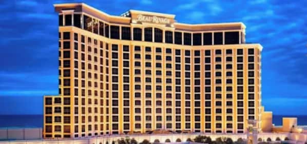 Un hotel grande de varios pisos con un estilo arquitectónico clásico, que presenta un letrero llamativo en la parte superior.
