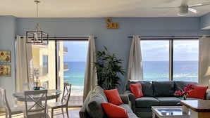 Un salón con vistas al océano, un balcón y un comedor.