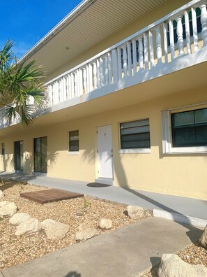 A two-story building with a balcony, a door, and windows. - Oceanview Across From The Beach (Ormond by the sea)