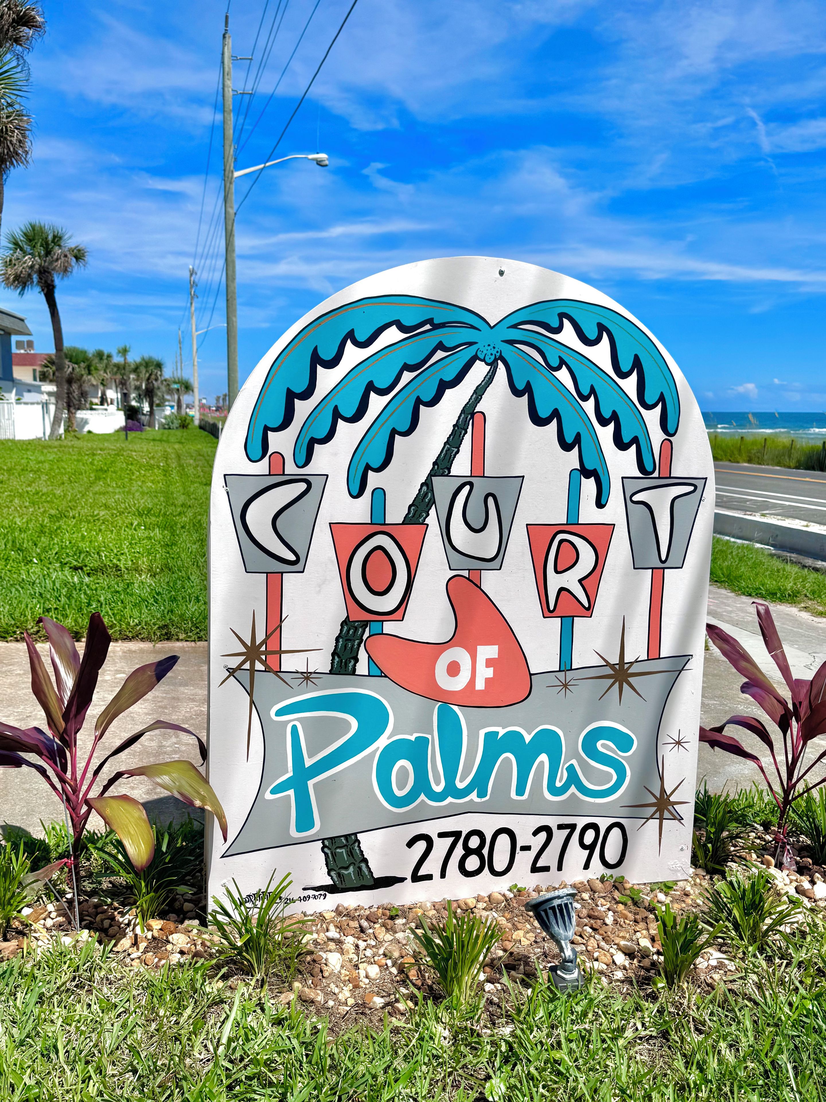 A sign with the text 'COURT OF PALMS' and a phone number '2780-2790'.