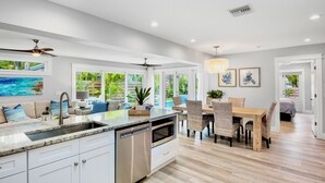 A modern kitchen with a central island, built-in oven, and dishwasher. - Blue Oasis West:  Private Pool & Spa | 2 King Beds | 5-Min Walk to Beach (Holmes Beach)