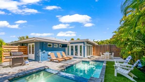 A backyard with a swimming pool, a barbecue area, and outdoor seating. - Blue Oasis West:  Private Pool & Spa | 2 King Beds | 5-Min Walk to Beach (Holmes Beach)