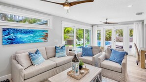 A spacious living room with a large sofa, two armchairs, a coffee table with a decorative item, and ceiling fans. - Blue Oasis West:  Private Pool & Spa | 2 King Beds | 5-Min Walk to Beach (Holmes Beach)