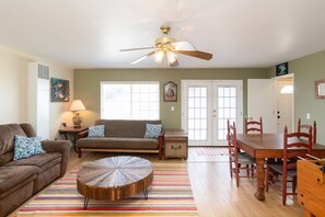 Relax in this inviting living area with a round coffee table, brown sofa, and dining table.